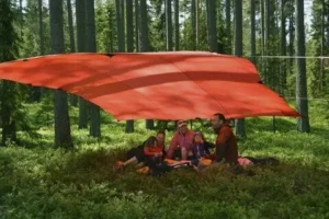 Hilleberg Tarp 20 UL viritettynä metsään useamman retkeilijän suojaksi.