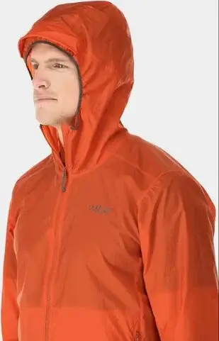 Mies oranssissa hupullisessa juoksutakissa vaalealla taustalla.