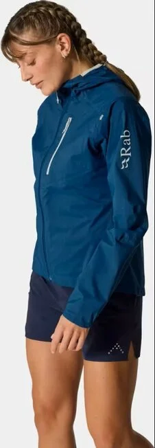 Nainen sinisessä Rab Women’s Downpour Trail Light Jacket -kuoritakissa.