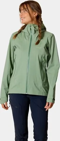 Nainen vihreässä Rab Women’s Firewall Light Jacket -kuoritakissa.