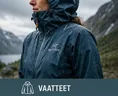 Retkeilijä teknisessä ulkoilutakissa sateisessa vuoristomaisemassa vaatekategorian kuvana.
